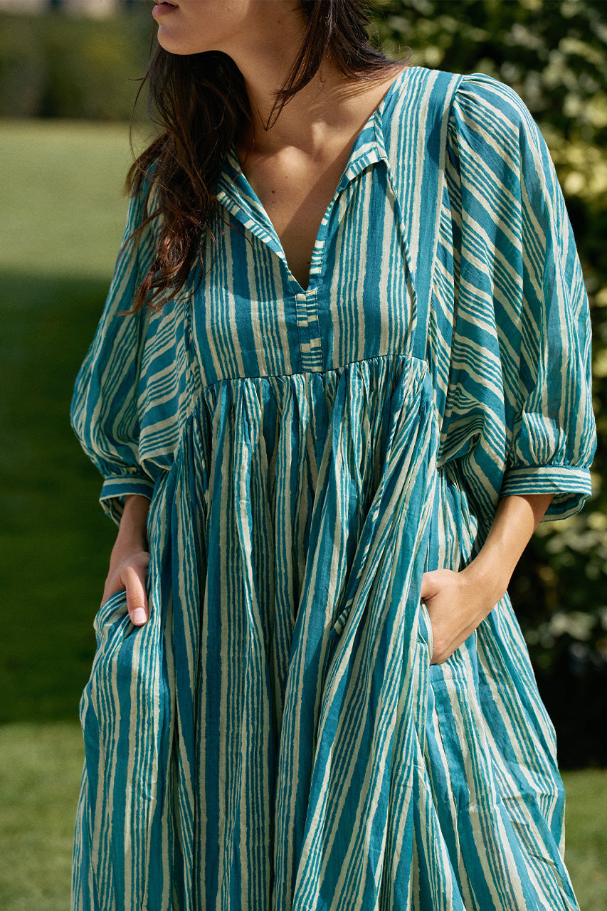 Close-up of woman outdoors wearing the Daughters of India Kyra Midi Dress in Spearmint, showing hands in hidden pockets and the relaxed V-neckline